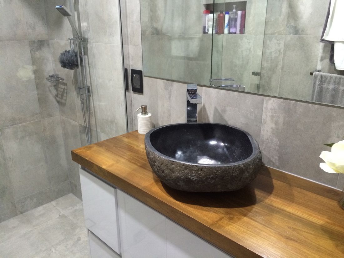 Dark sink done out of beautiful river stone in the bathroom 