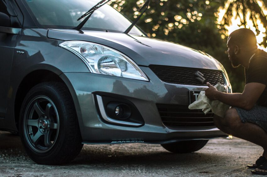 A man is cleaning his big car